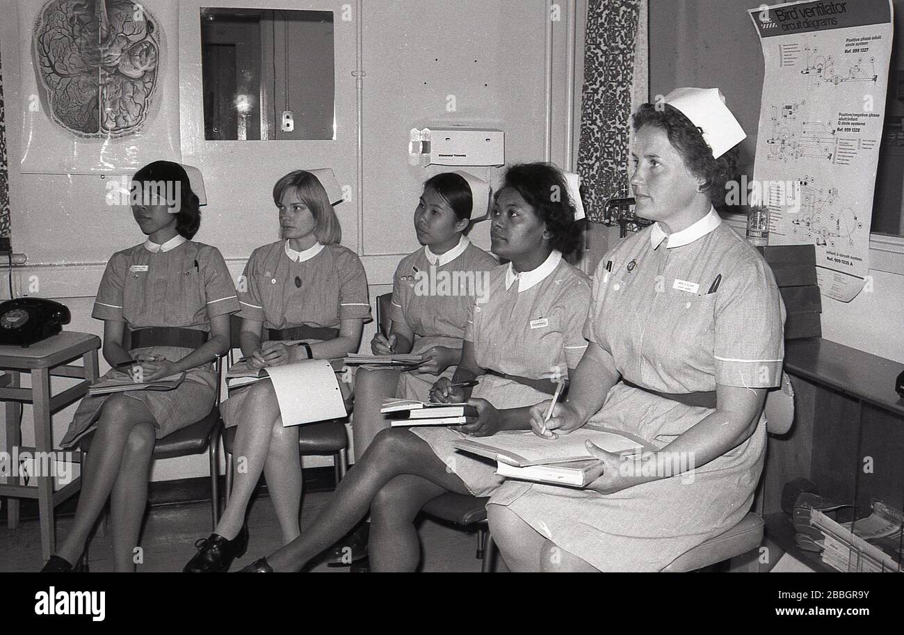 1970s, historical, uniformed female nurses with notebooks sitting in a