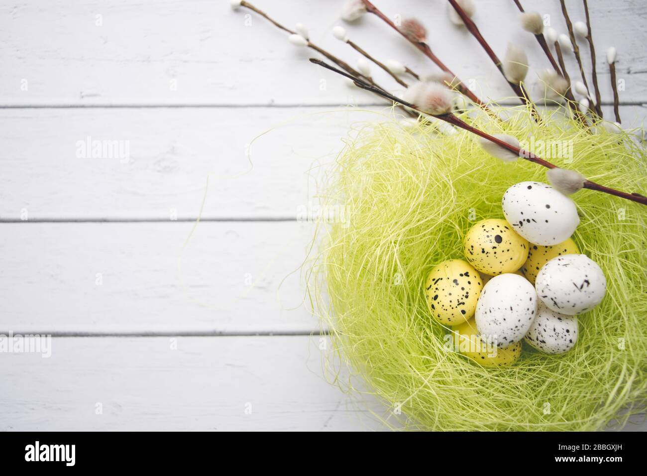 Easter decorations. Willow twigs and decorative Eggs in nests on wooden background Stock Photo