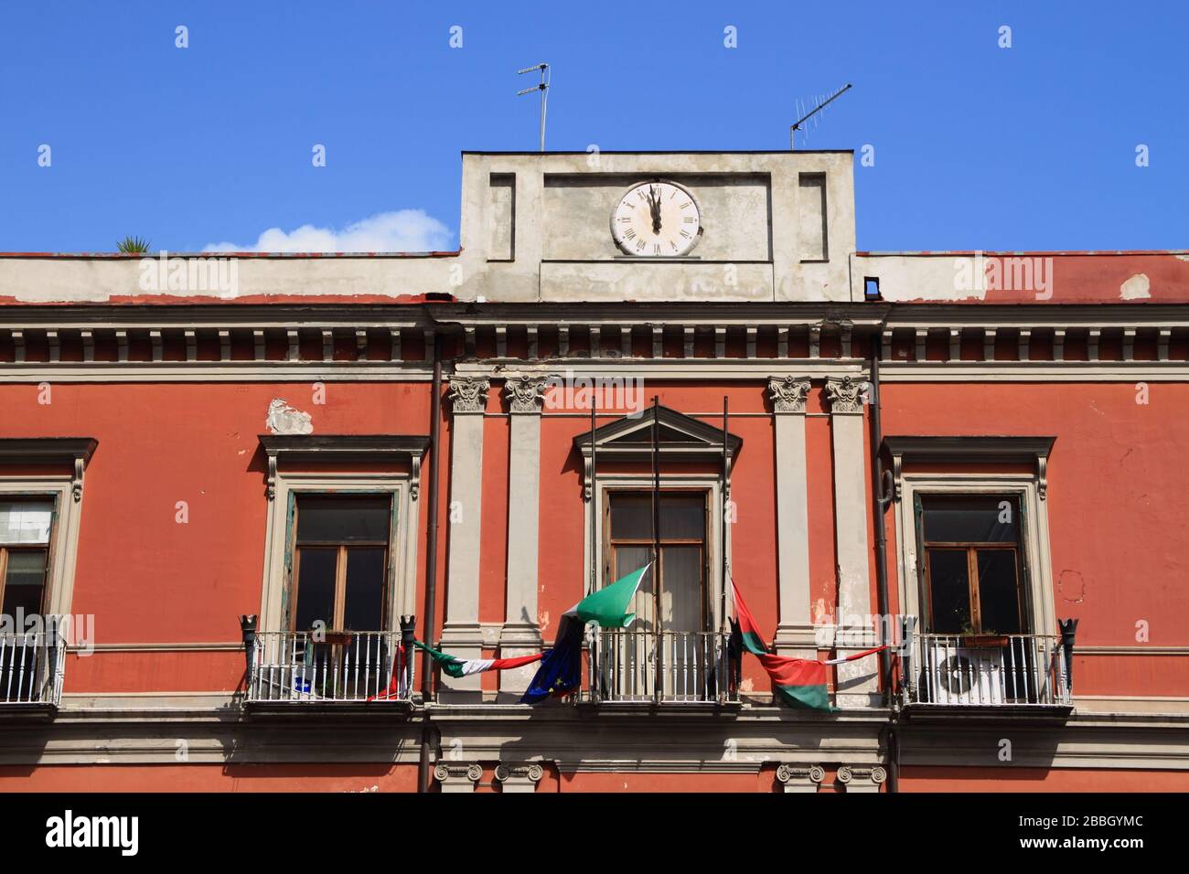 Flag of Italy, Europe and the Municipality put to half auction on the facade of the Town Hall in memory of the victims of covid-19, and honor all doct Stock Photo