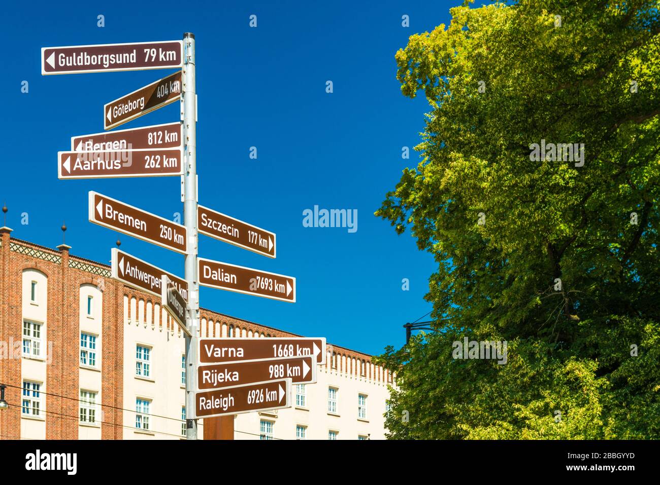 Street sign with directions pointers and distances to the different cities of the world. Rostock, Germany Stock Photo