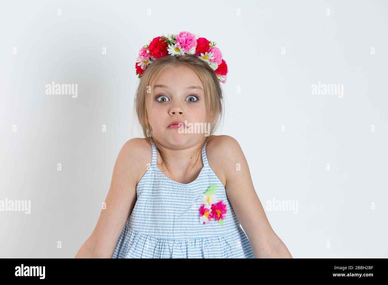 Closeup portrait puzzled clueless kid girl young woman big surprised eyes shrugging shoulders about to tell I do not know isolated on white gray backg Stock Photo