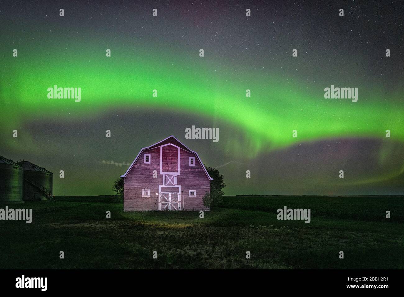 Aurora dancing over old red barn in rural Manitoba, Canada Stock Photo