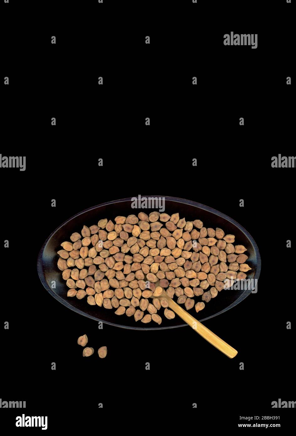 Dried dark brown Desi chickpeas, also called Chana Black, in a black