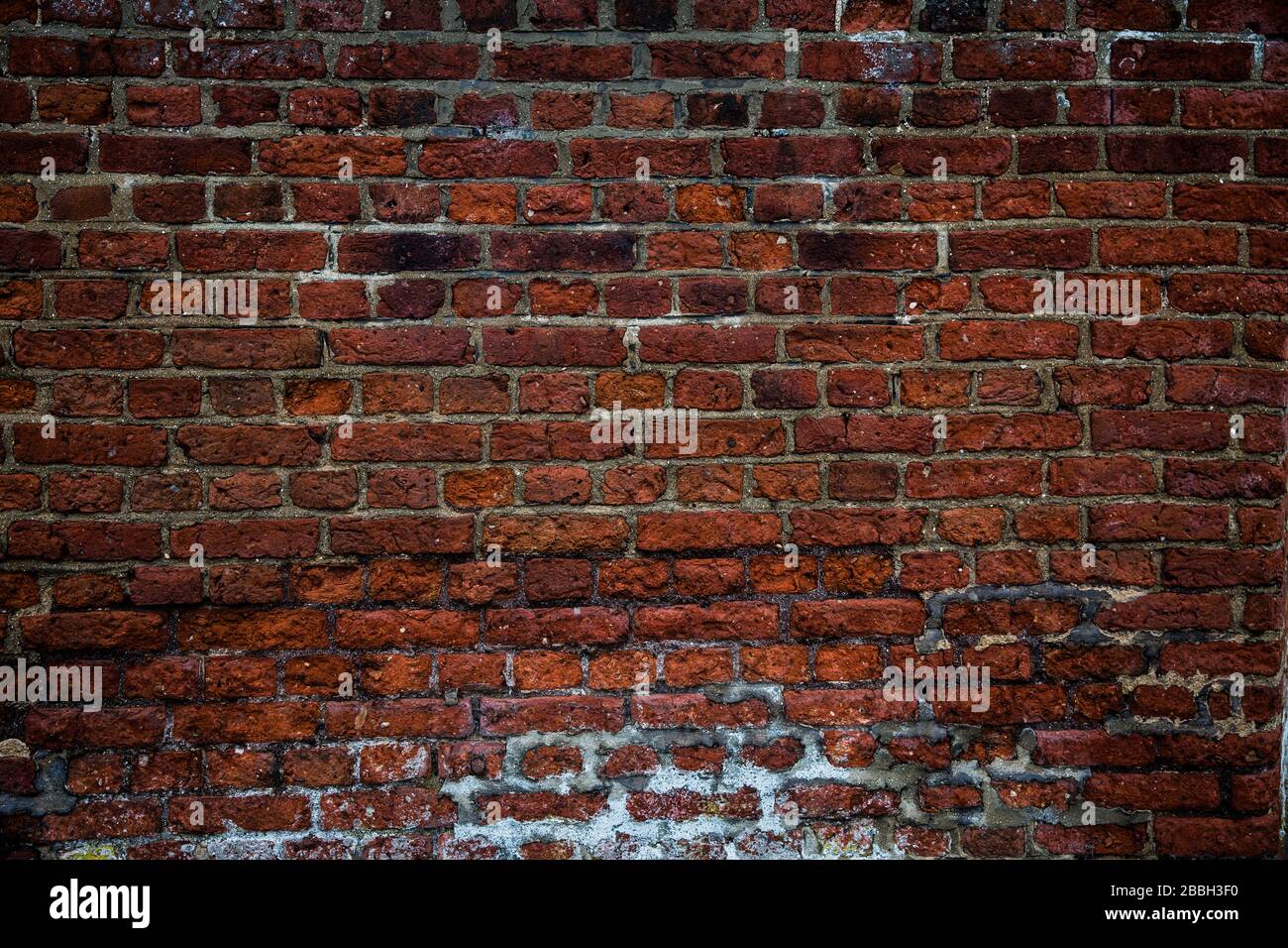 A full frame background of a rough and textured brick wall with visible wear and tare and copy space Stock Photo