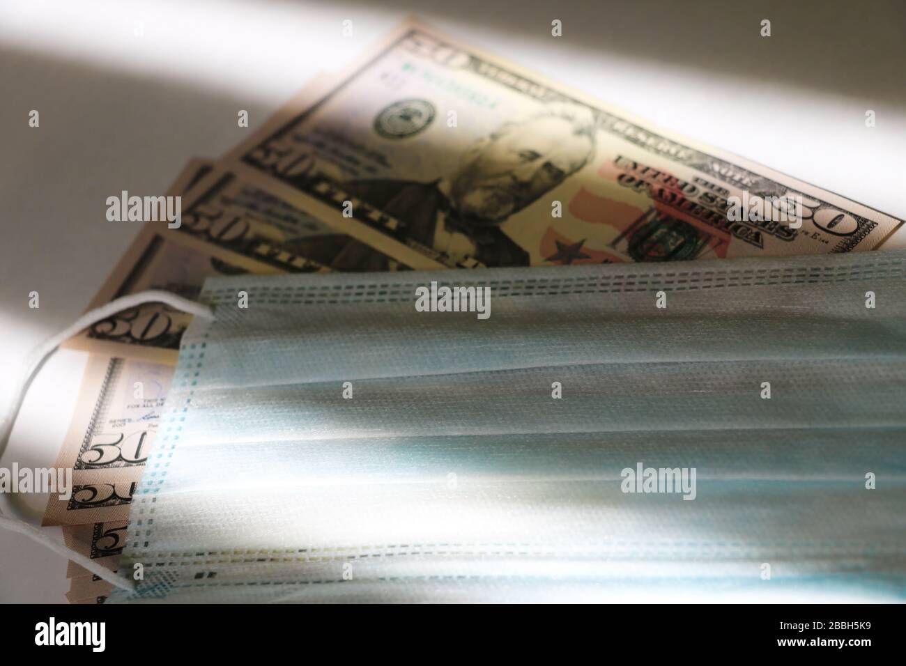 Coronavirus. Medical mask on top of US dollars and Euro. Global pandemic alert Stock Photo