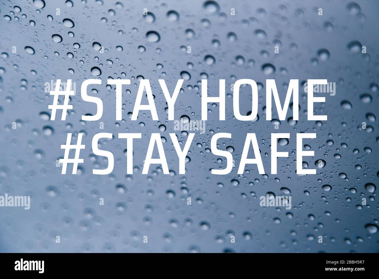 Stay at home social media campaign for coronavirus prevention. Stay home stay safe concept. Close up of rain drops on the window at background Stock Photo