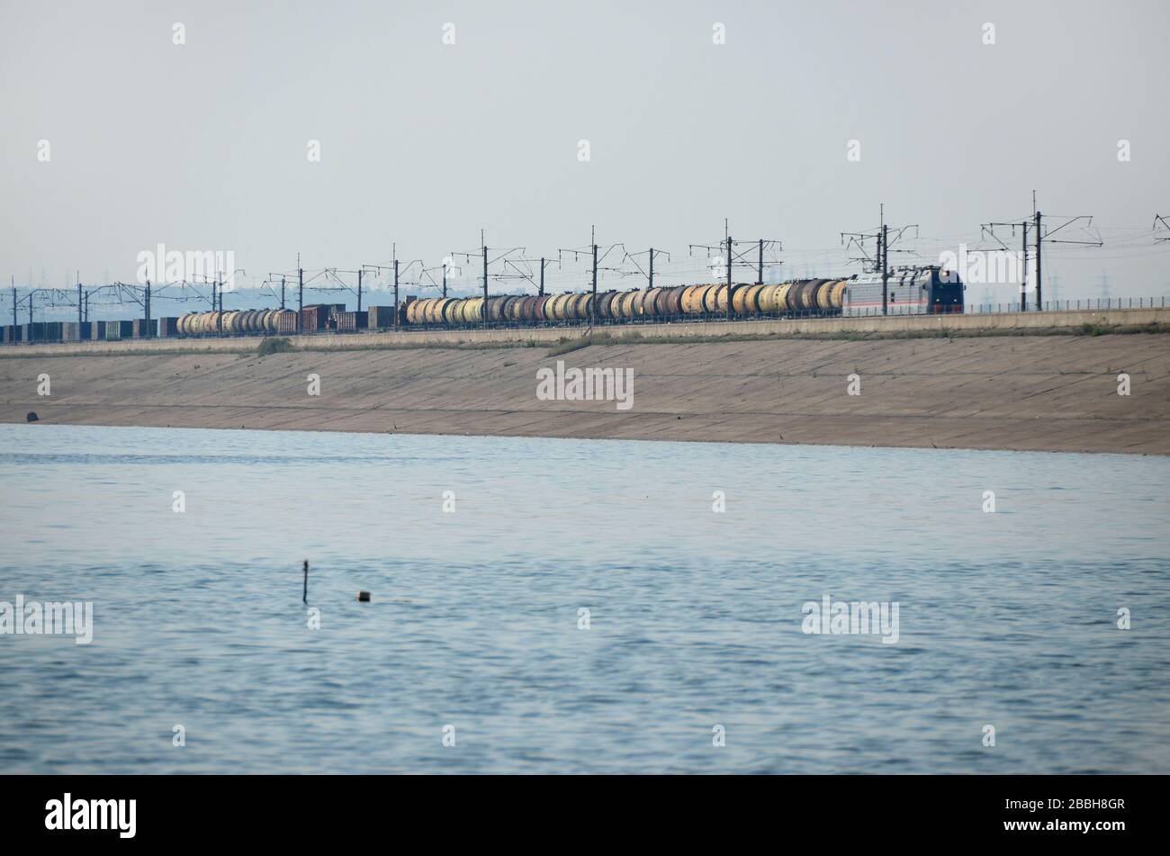 A class TEP 70 diesel locomotive with oil tanker wagons on the hydroelectric dam of Bratsk, Russia. This the BAM railway line, Baikal Amour Magistral. Stock Photo