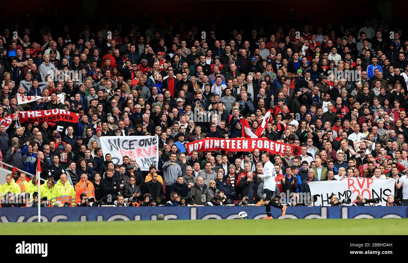 Manchester United fans in the stands hold up banners celebrating their