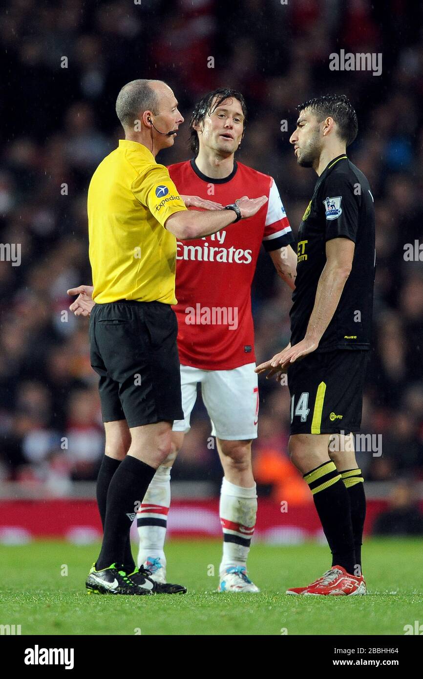 Referee Mike Dean, Arsenal's Tomas Rosicky and Wigan's Jordi Gomez. Stock Photo