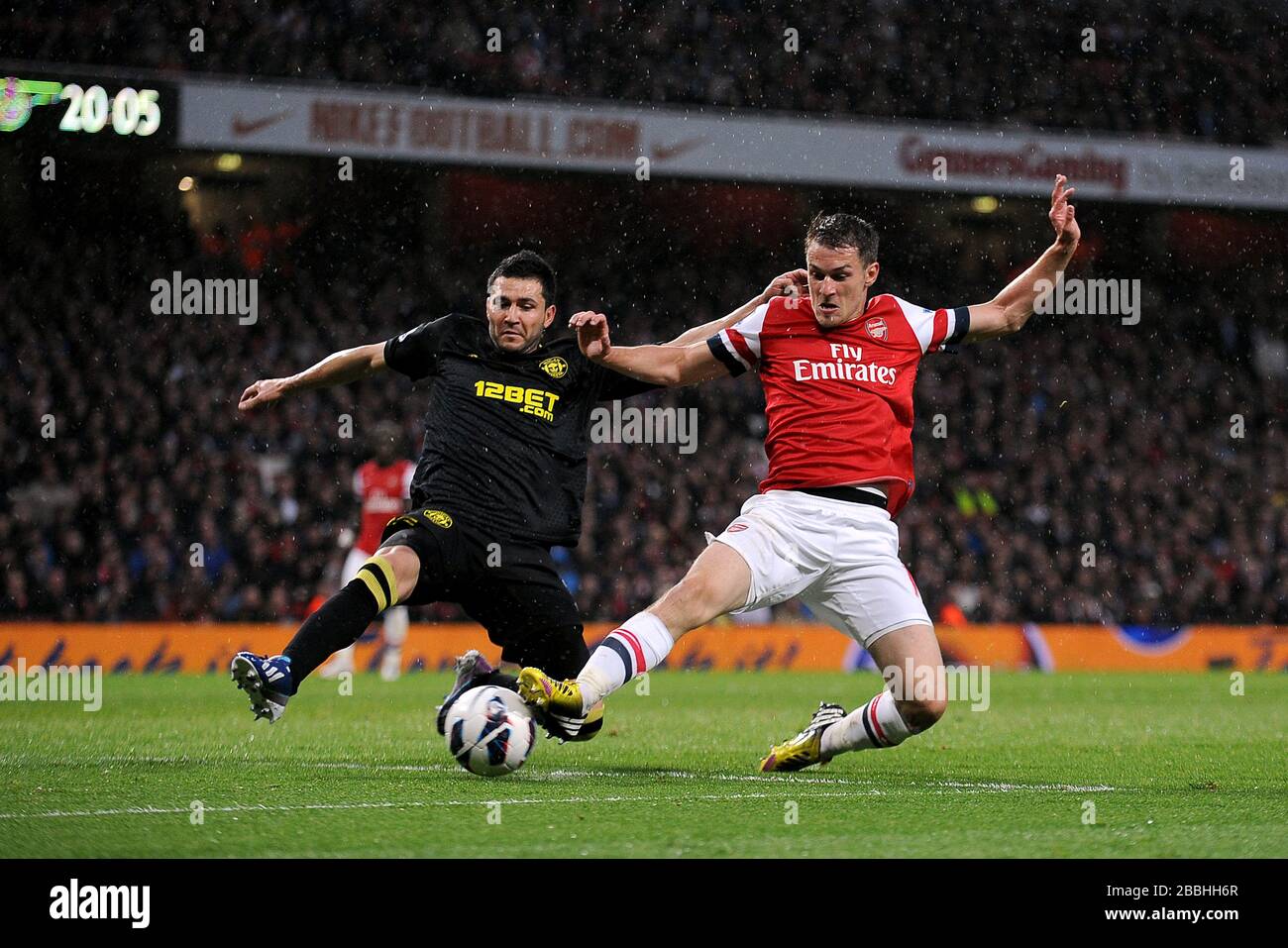 Arsenal's Aaron Ramsey (right) and Wigan's James McArthur (left) fight for the ball. Stock Photo