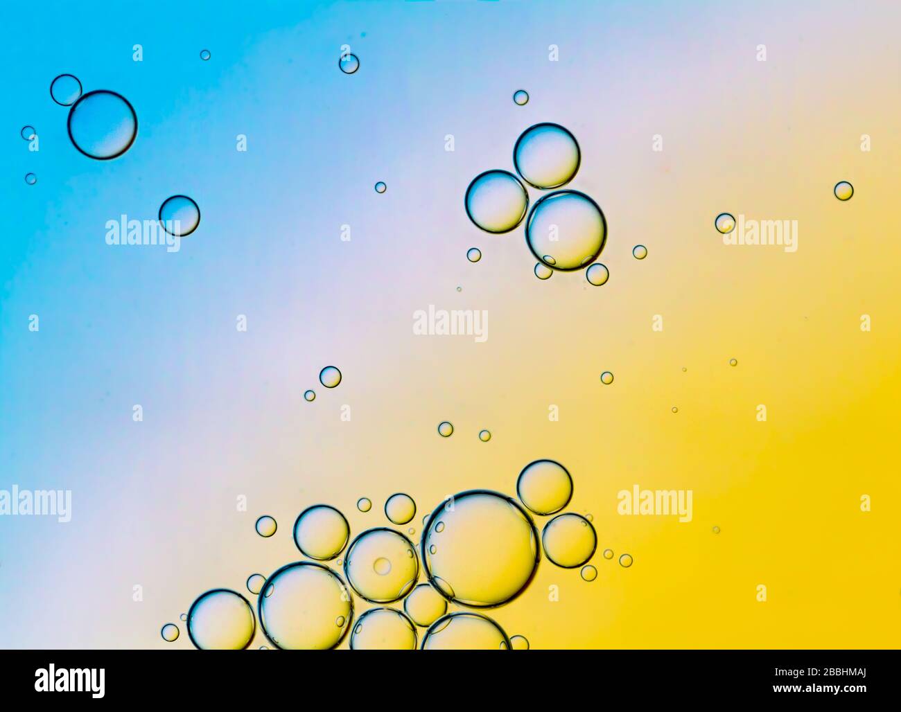 Abstract Background of Oil Bubbles on Water Surface Cyan Orange palette. Macro close-up shot. Stock Photo
