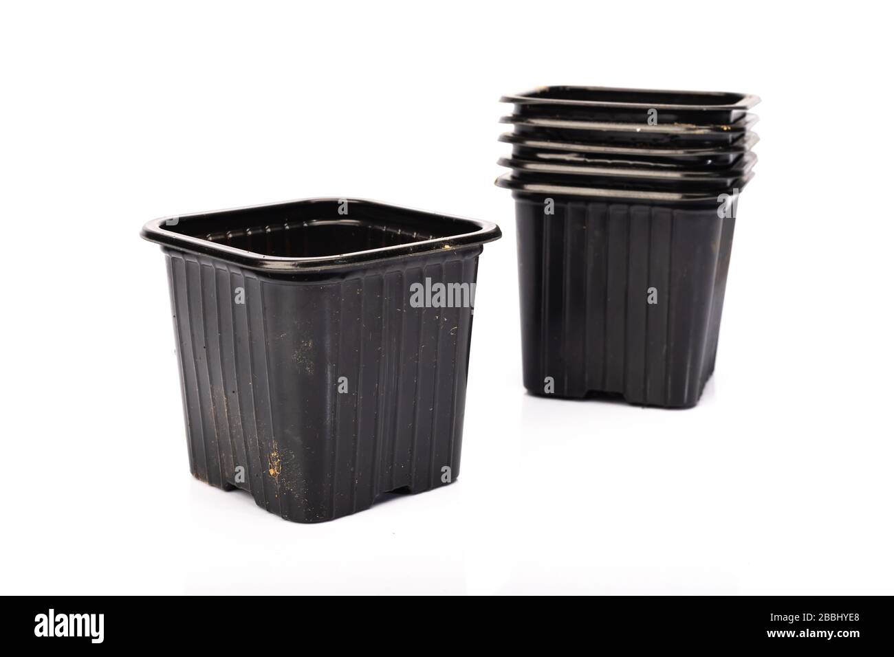 used black plastic gardening bucket waiting for spring on white