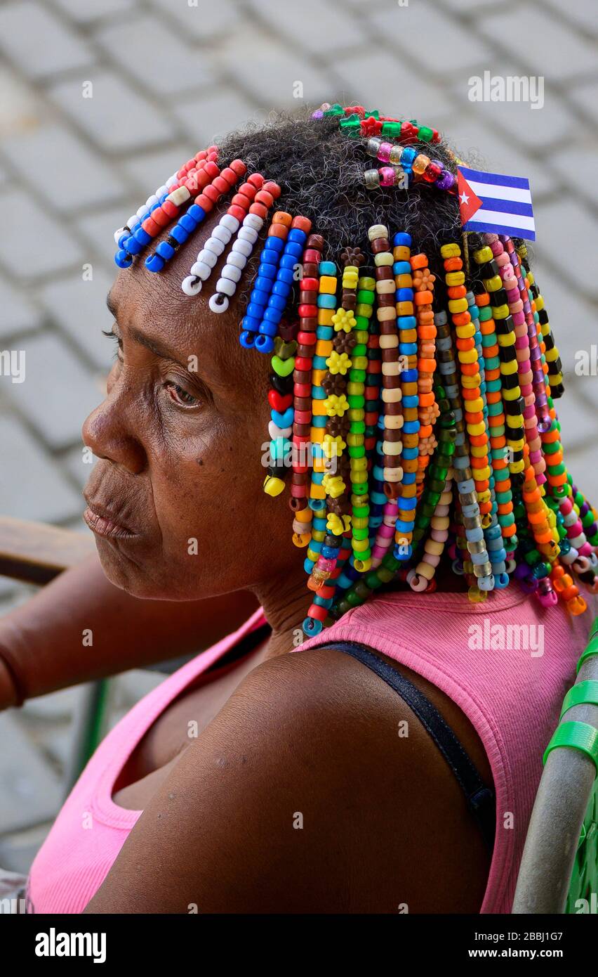 Woman with hair beads with Cuban flag, Havana Vieja, Cuba Stock Photo