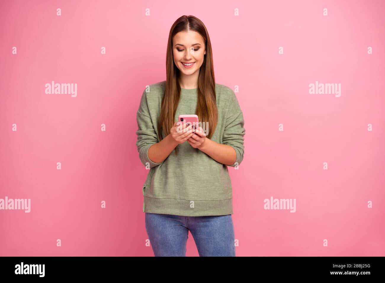 Portrait of positive cheerful girl use smartphone read social network novelty wear good look jumper isolated over pastel color background Stock Photo