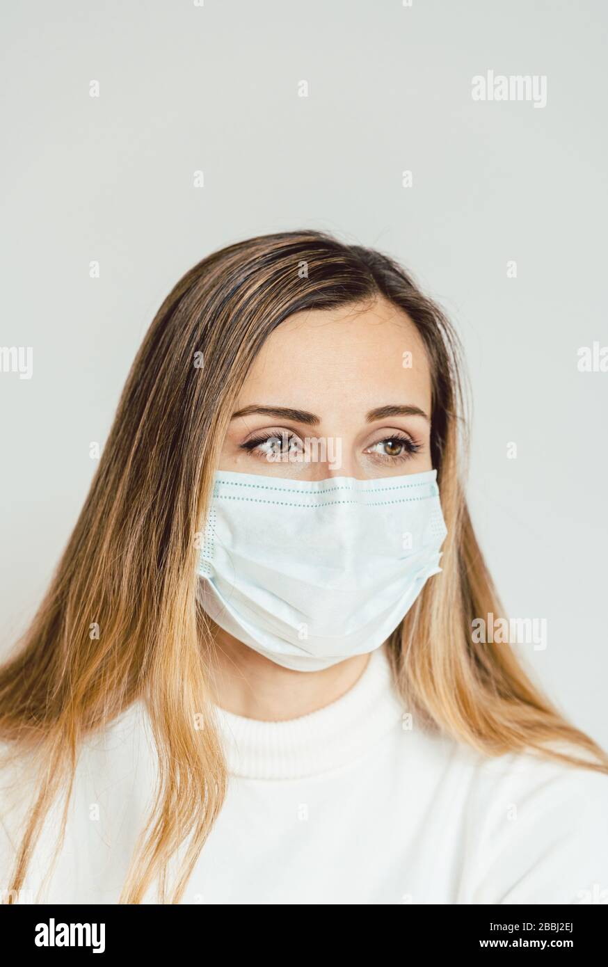 Anxious woman with face mask worried about the Covid-19 outbreak Stock Photo