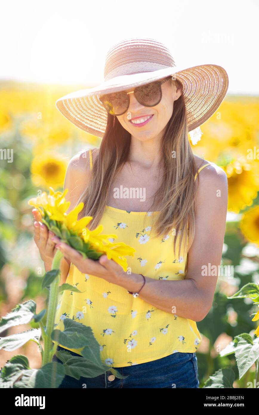 Beautiful Woman With Hat in a Sunflower Field in summertime Stock Photo ...
