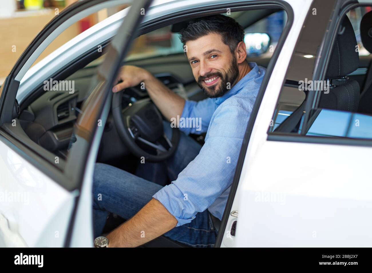 Young man in the car showroom Stock Photo - Alamy