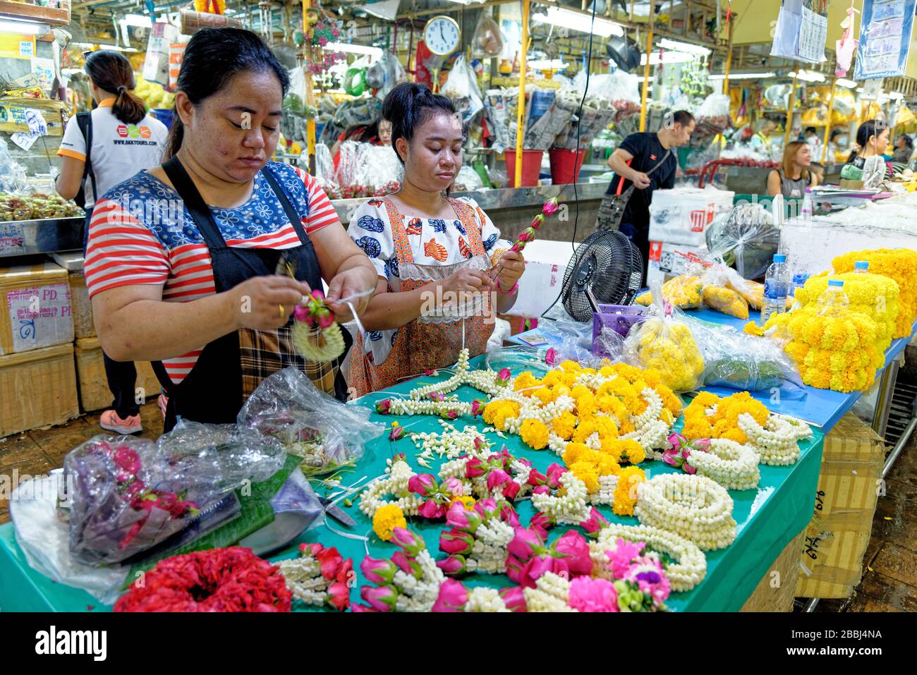 Womnn making daisies flowers arrangements for offrands in Pak Khlong