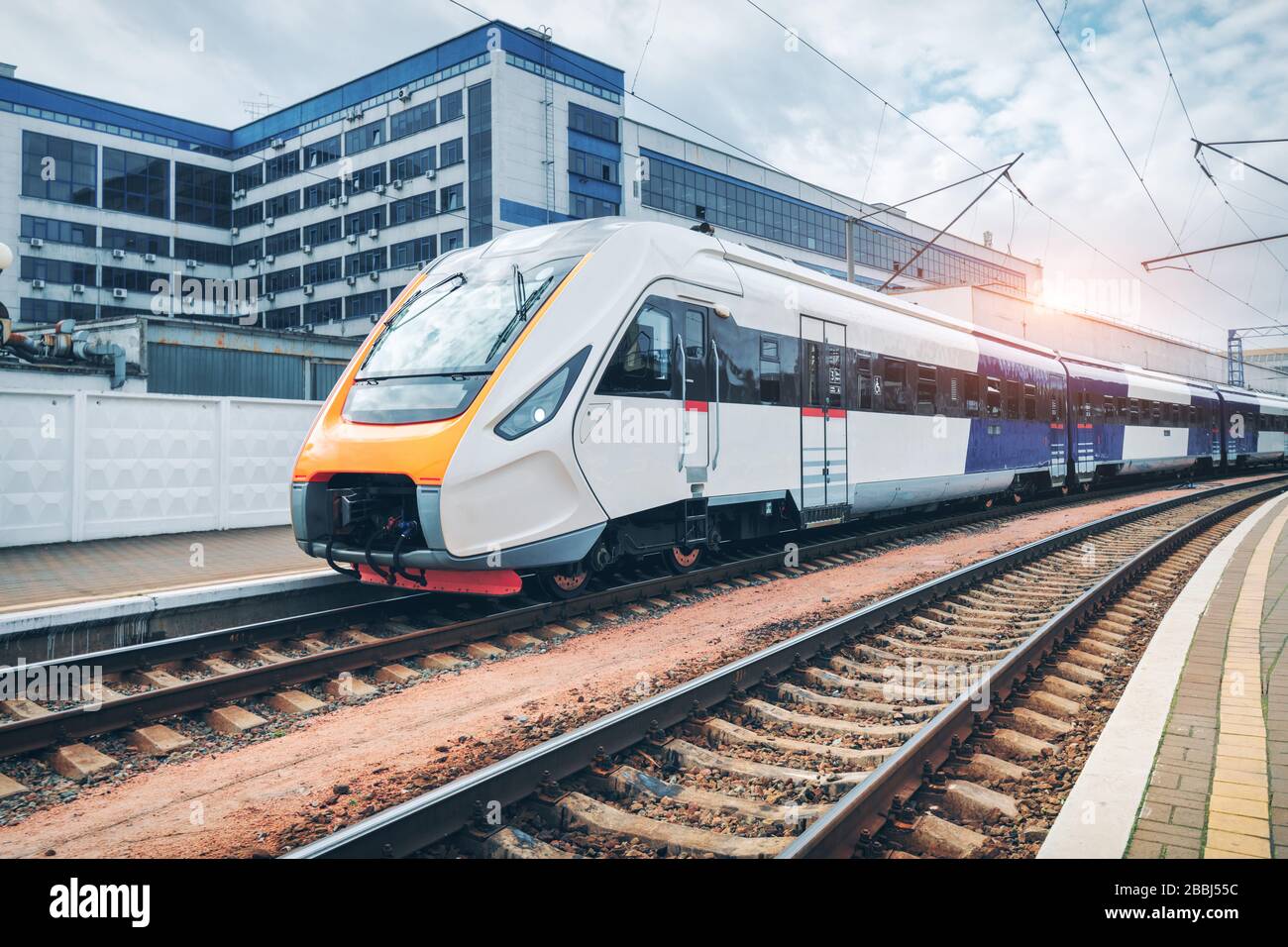 High speed train on the railway station at sunset Stock Photo