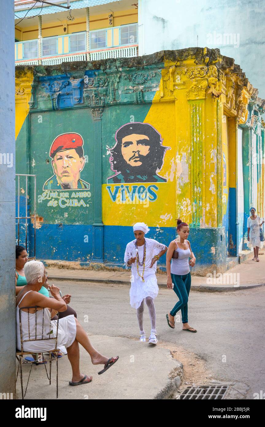 People walk by Murals with Che and Chavez,  on outside of produce market, Havana Vieja, Cuba Stock Photo