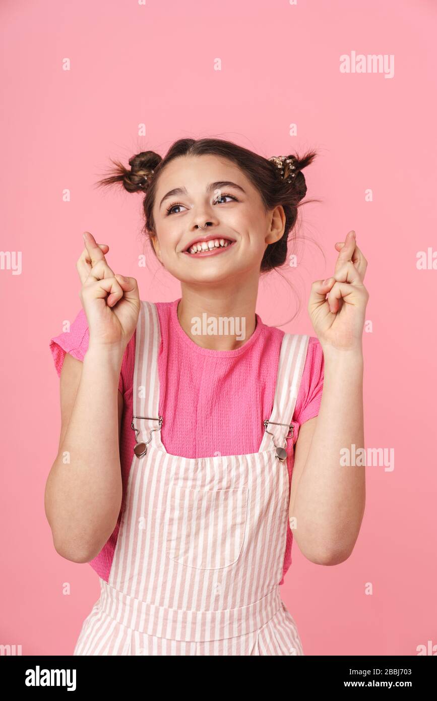 Photo of funny girl with nose ring holding fingers crossed for good luck  and smiling isolated over pink background Stock Photo - Alamy