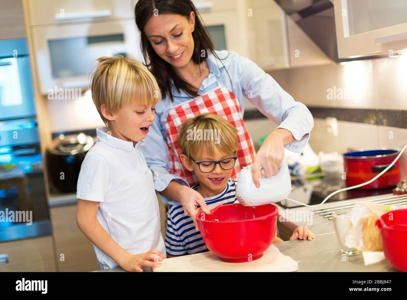 Mother and children cooking at home Stock Photo