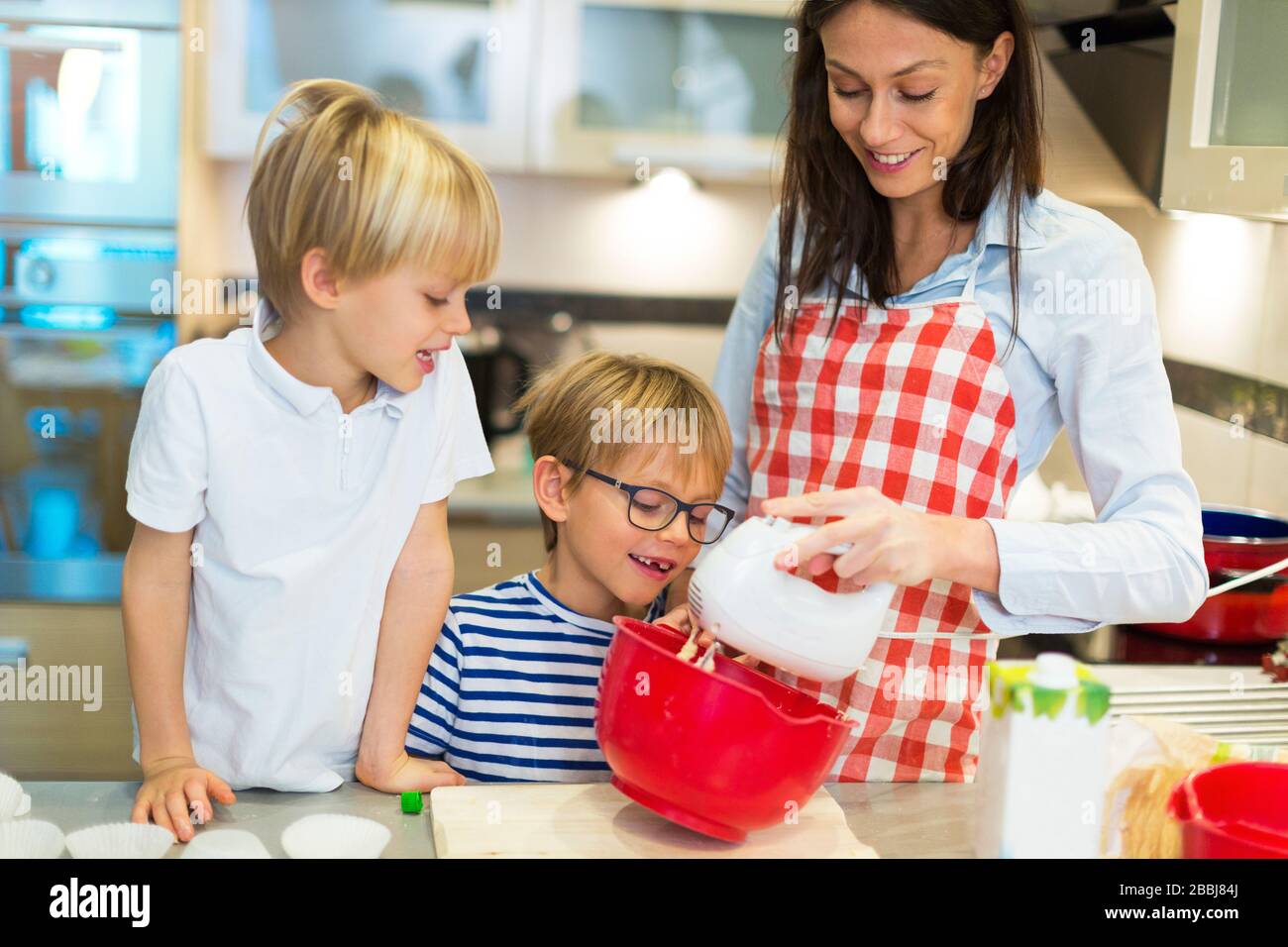 Mother and children cooking at home Stock Photo