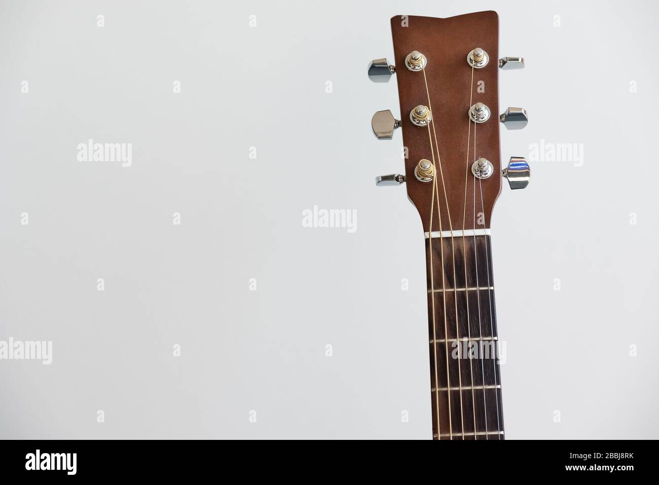 Guitar fretboard closeup, view of the neck of the guitar and strings on white background