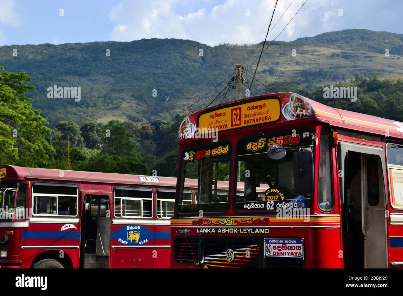 Sri Lanka - March, 2017: Red buses on a bus station on the background of mountains. Ashok Leyland Indian vehicle Stock Photo