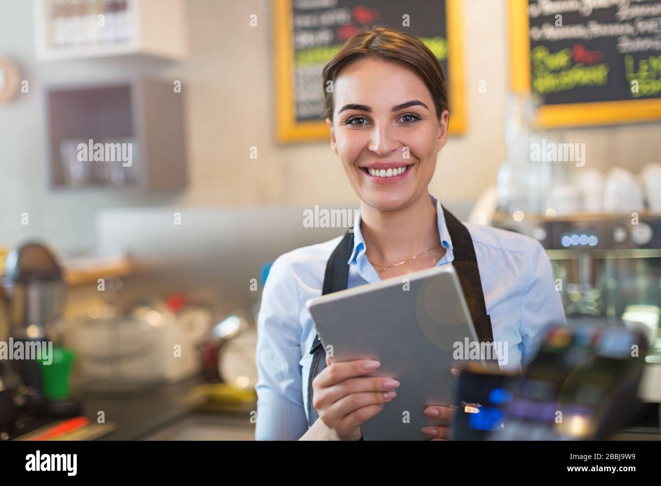 Woman working in coffee shop Stock Photo
