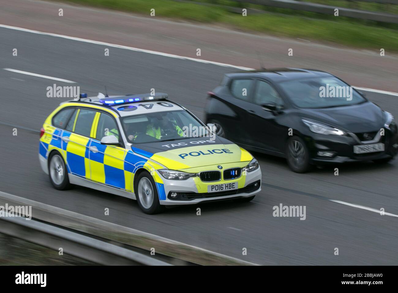 A TAC OPS BMW police car speeding to an emergency on the M6 motorway near Preston in Lancashire Stock Photo