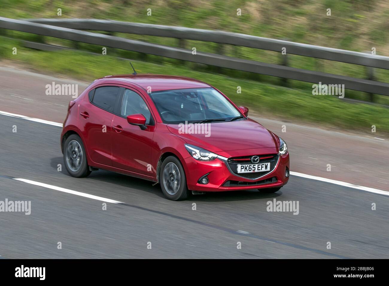 2015 Mazda 2 Sport Nav red car petrol driving on the M6 motorway near Preston in Lancashire, UK Stock Photo