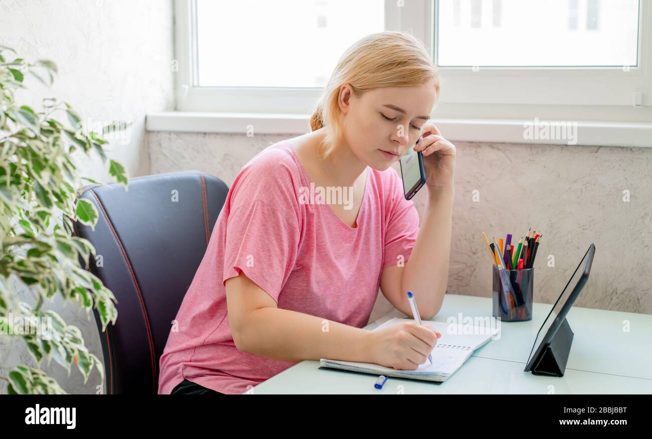 Beautiful woman using smartphone and tablet. Working from home. Online shopping Stock Photo