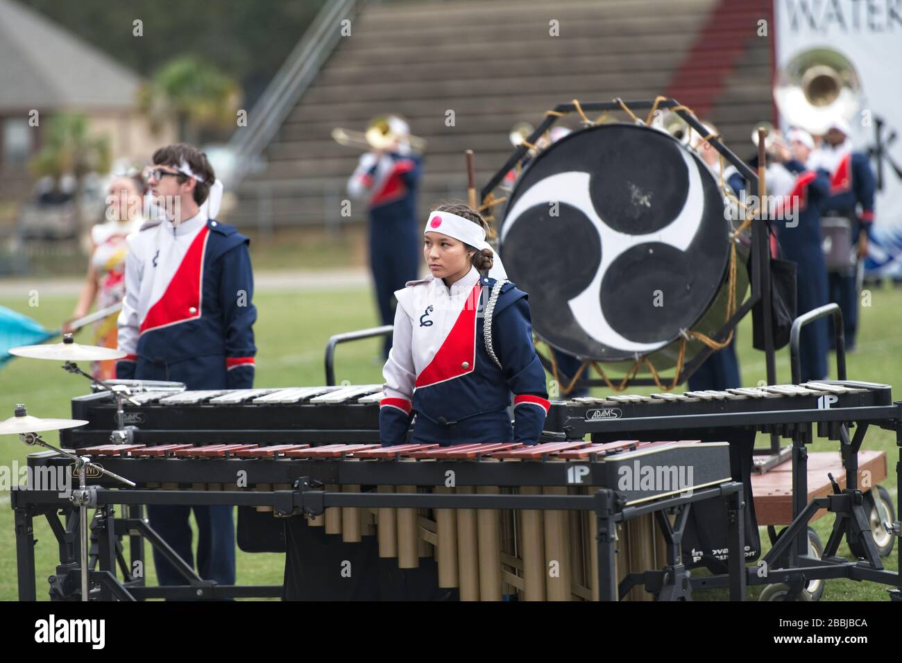 Asian American teenage girl plays the marimba in a high school marching