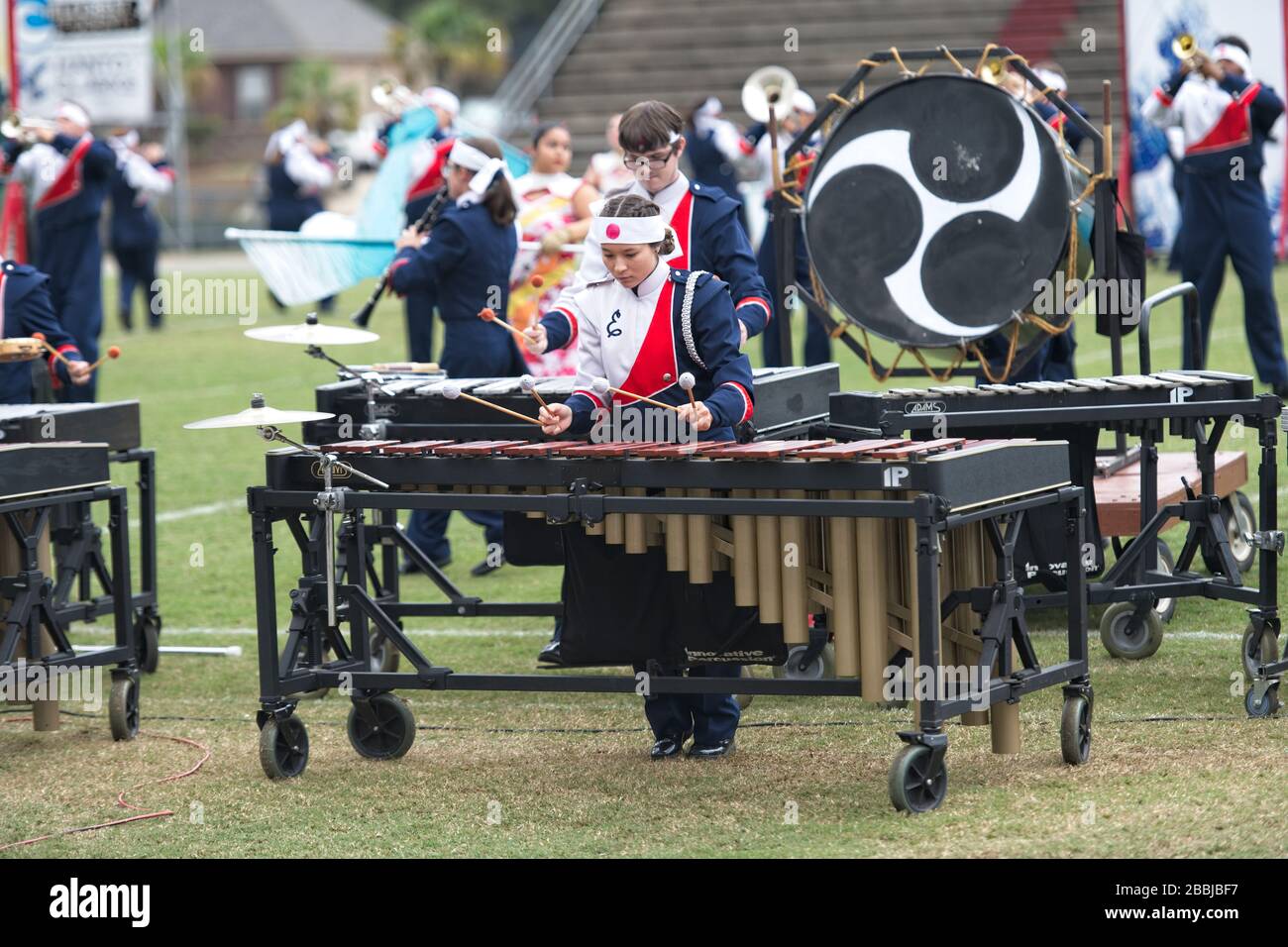 Asian American teenage girl plays the marimba in a high school marching