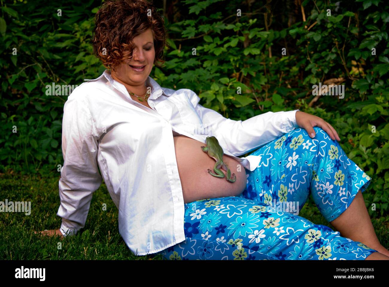 Pregnant woman with frog on belly Stock Photo