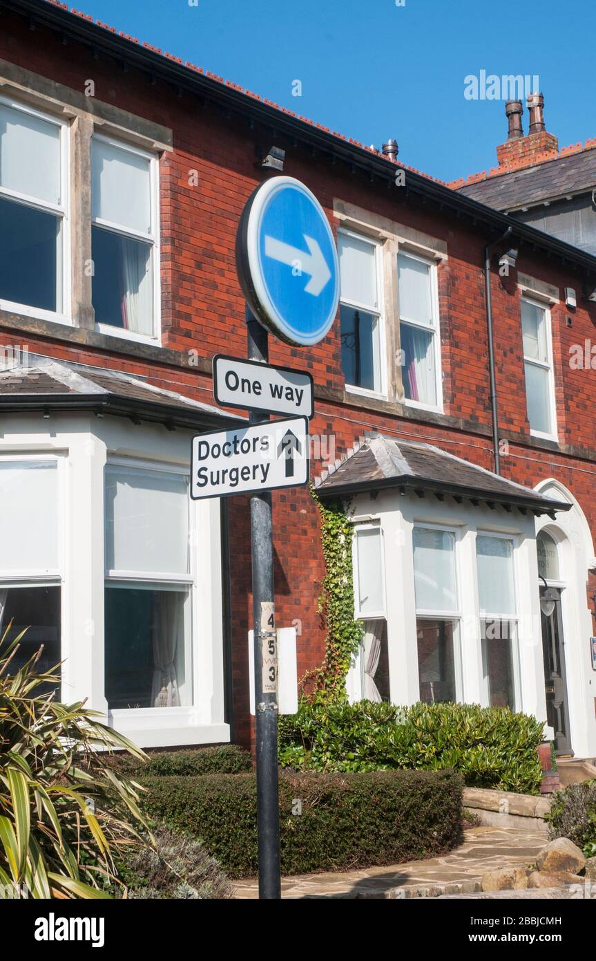 One Way traffic turn right and Doctors Surgery signs in juxtaposition on post together. Stock Photo