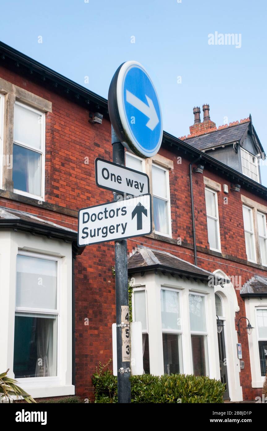 One Way traffic turn right and Doctors Surgery signs in juxtaposition on post together. Stock Photo
