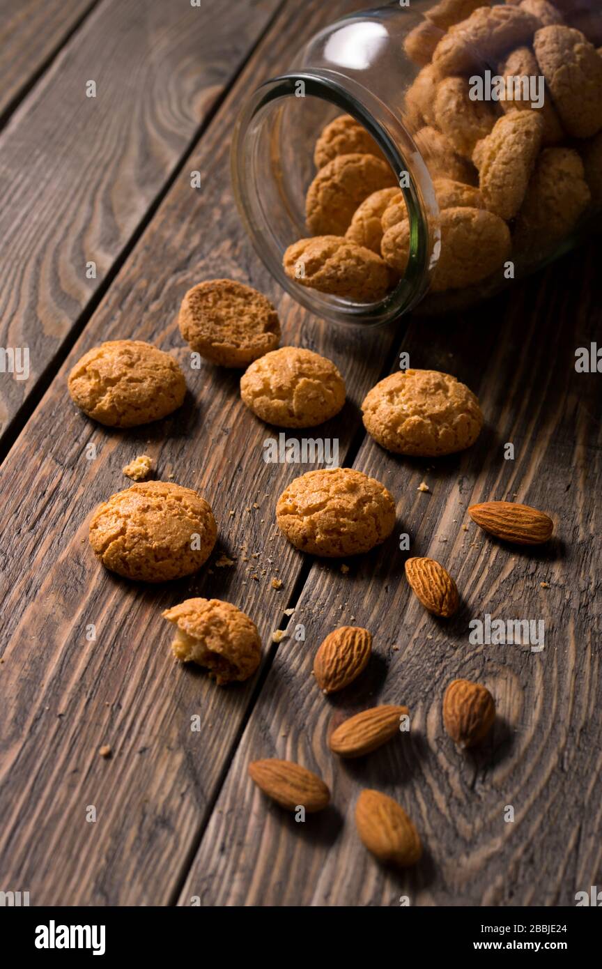 Italian amaretti biscuits poured out from a jar. Crunchy almond cookies