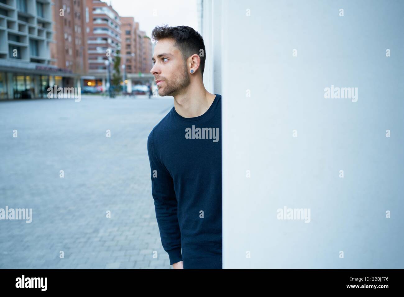the modern man in casual clothes leaning against a wall Stock Photo