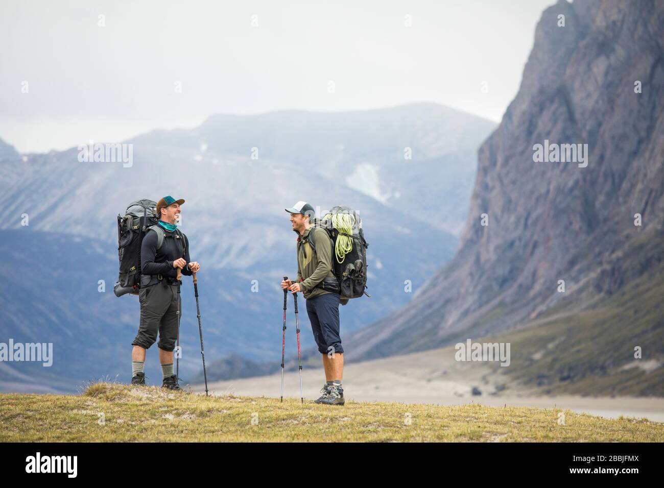 Two friends share a laugh while backpacking in Akshayak Pass Stock Photo