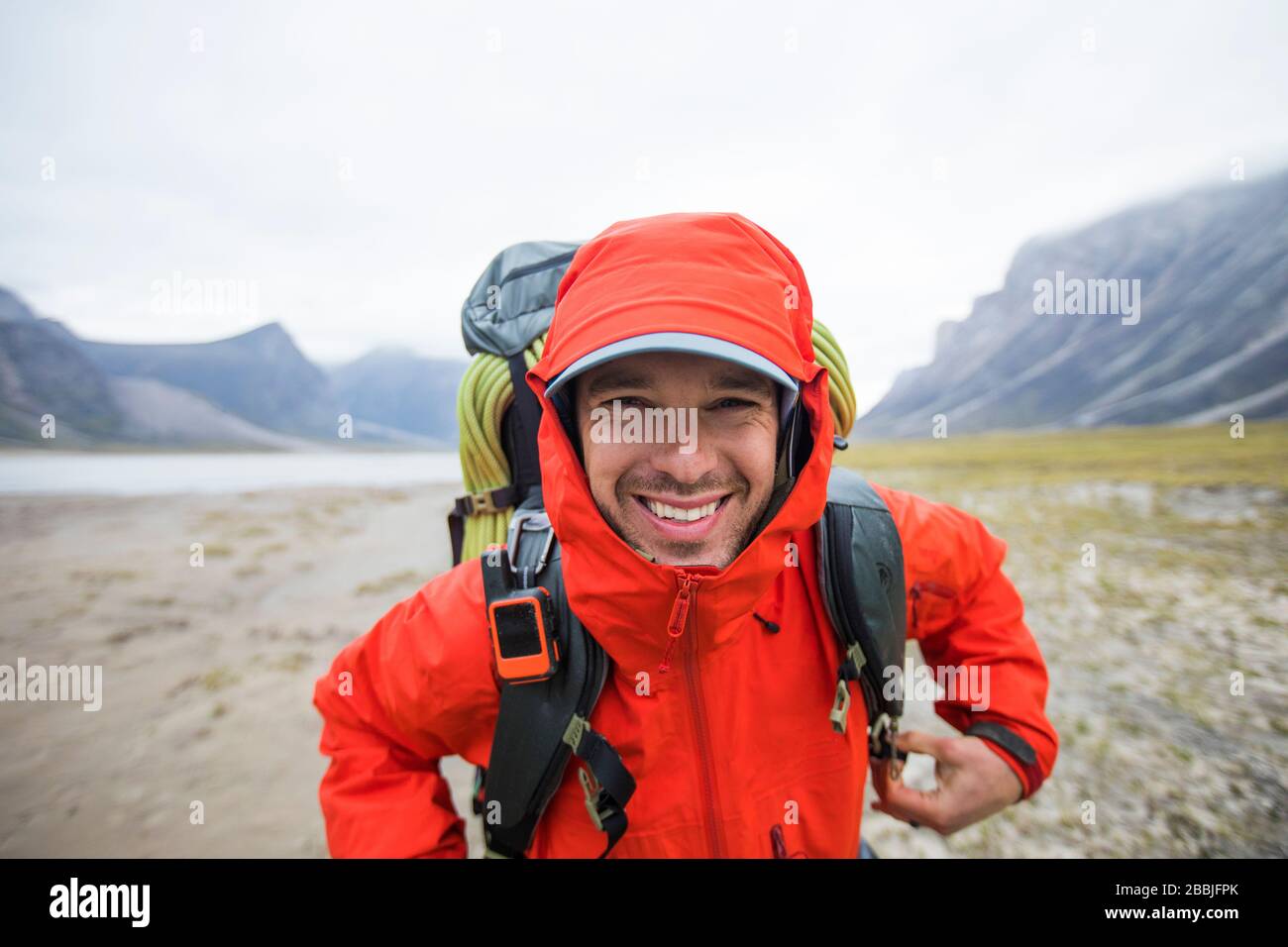 Portrait of happy backpacker in remote location. Stock Photo