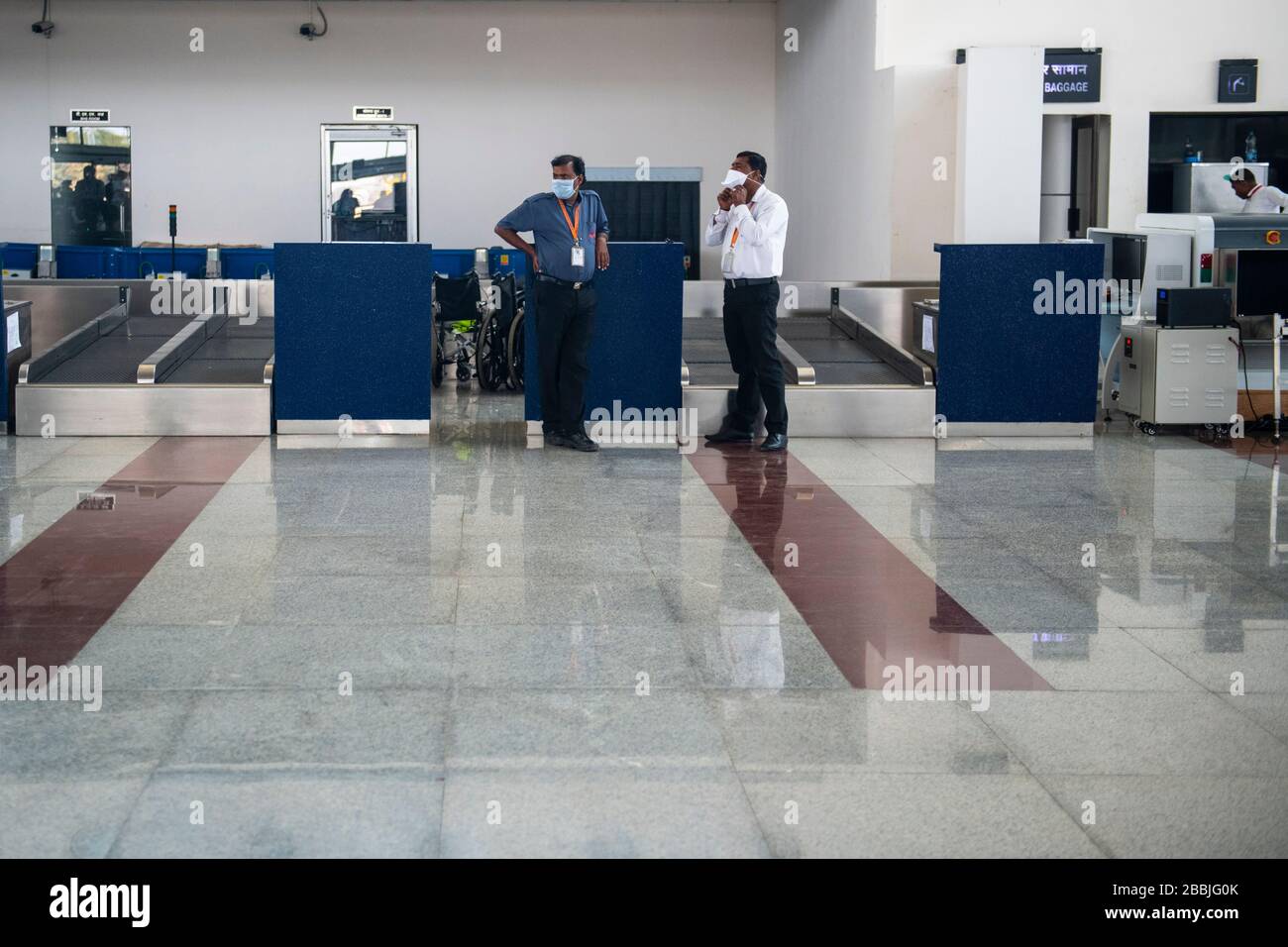 Airline staff wearing face masks conversing at a deserted airport in Khajuraho, Madhya Pradesh, India, during the international health crisis caused b Stock Photo