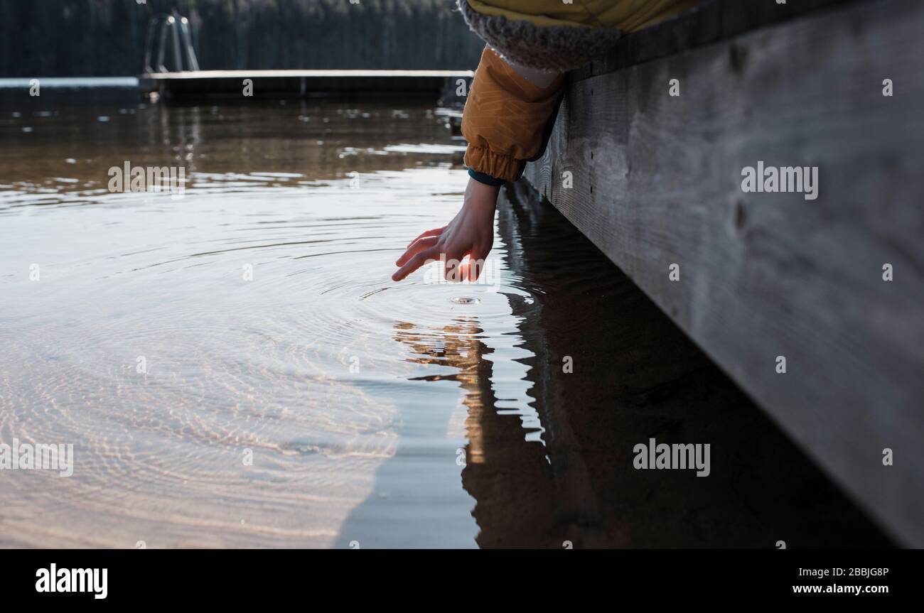 child's hand flicking sea water at the beach in Sweden Stock Photo
