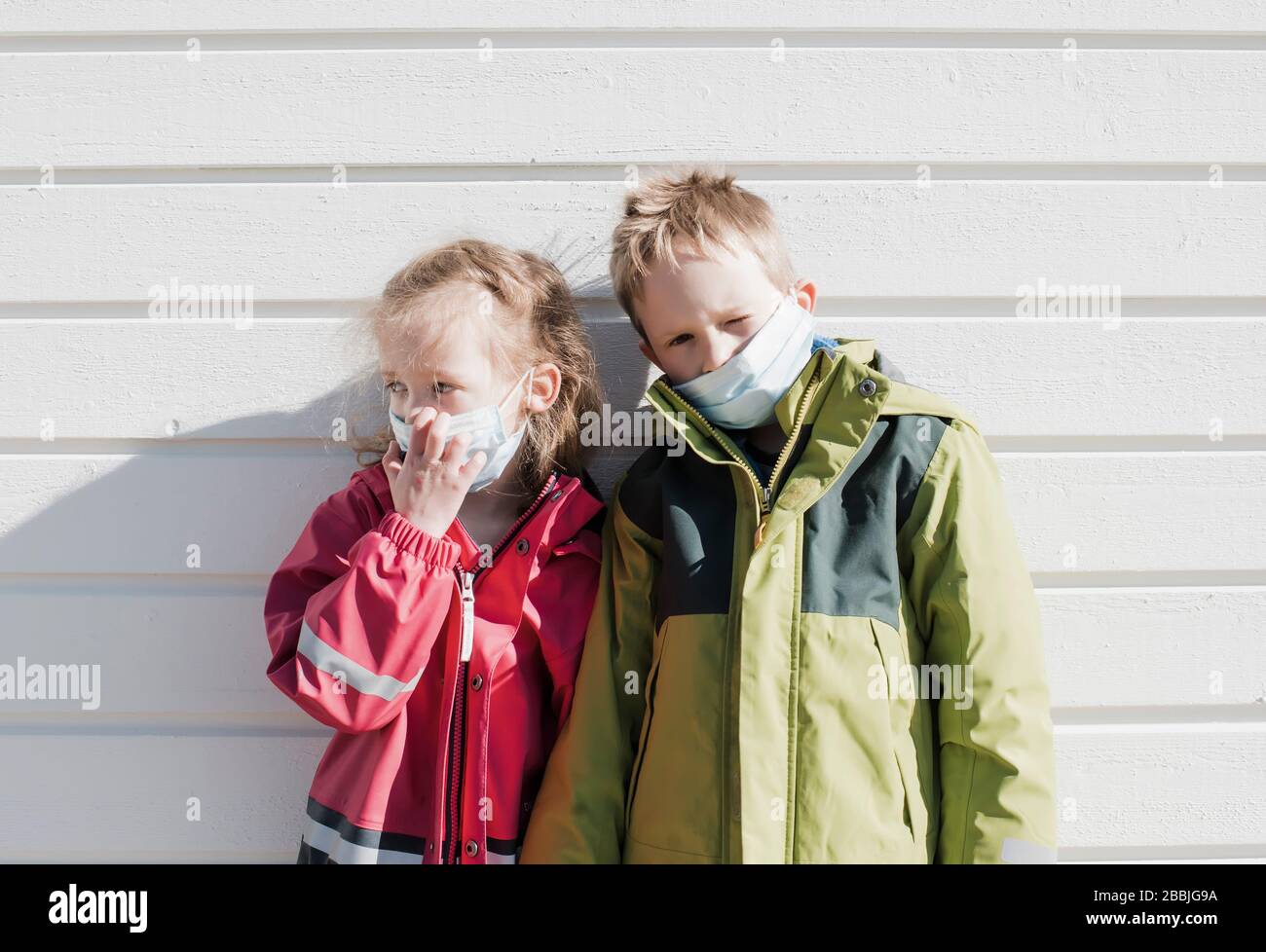 siblings wearing medical masks to protect from corona virus Stock Photo