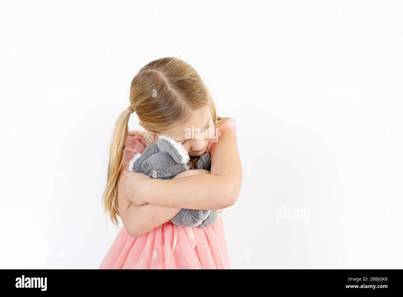Blond little girl hugging koala stuffed animal indoors Stock Photo - Alamy
