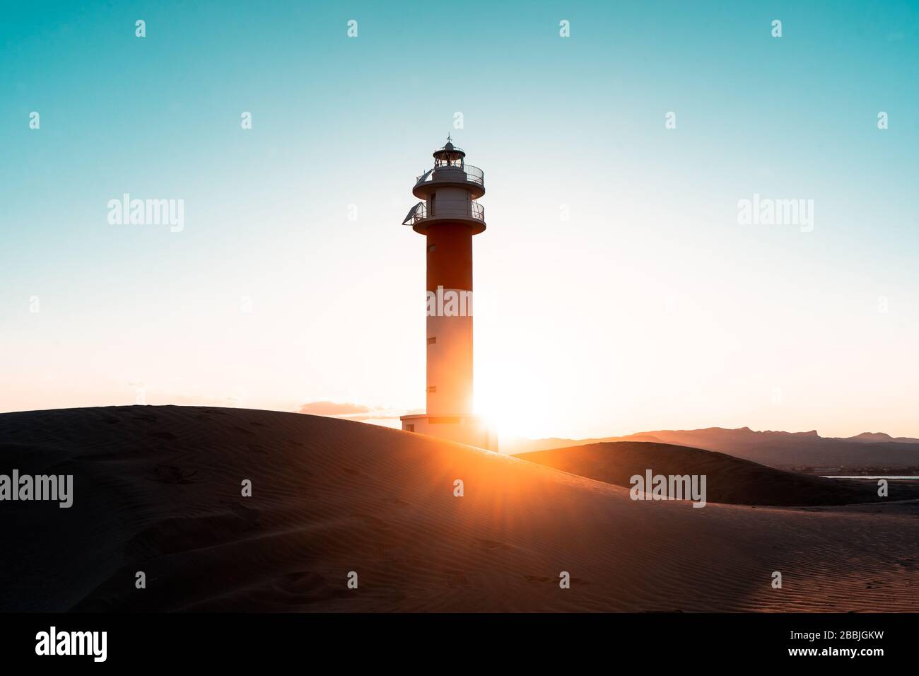 far lighthouse water sky sunset Stock Photo