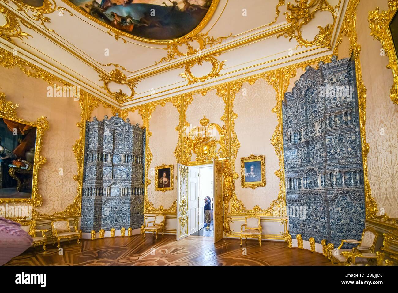 Inside one of the grand palatial rooms with gold trim and artwork on the ceilings in Catherine Palace in Pushkin Russia. Stock Photo