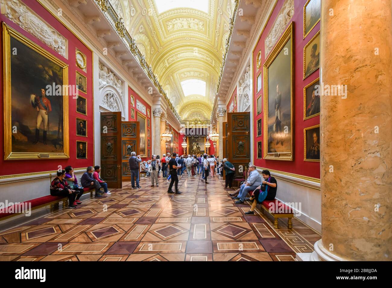 Tourists visit an indoor gallery hall of paintings in the Royal Hermitage museum. Stock Photo
