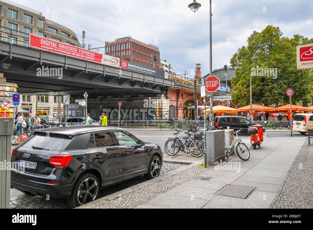 A busy intersection of train, cars and pedestrians near Hackescher Market in the urban center of Berlin Germany. Stock Photo